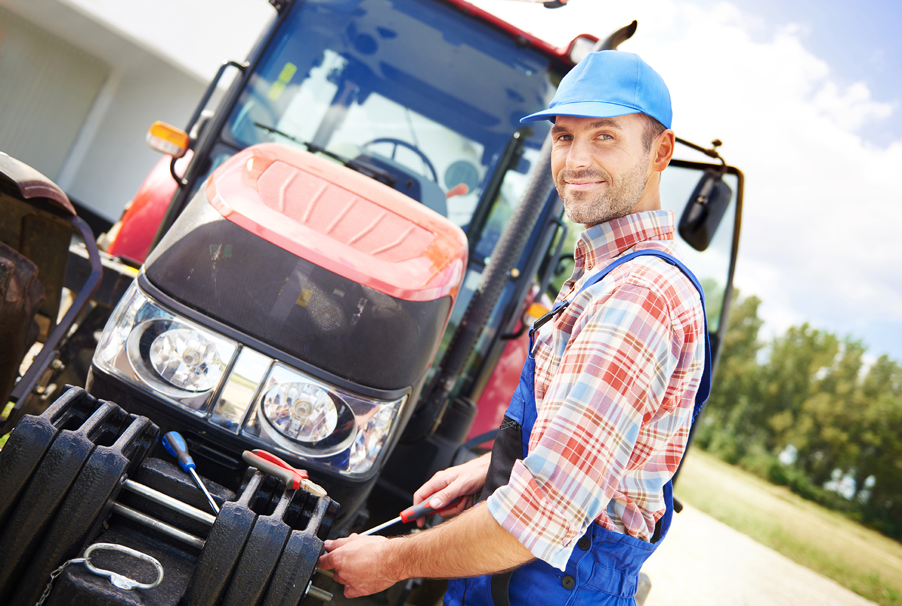 Farmer repairing his big tractor