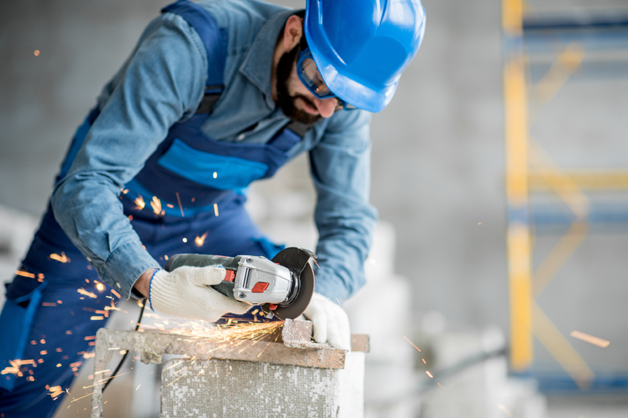 Builder cutting metal indoors