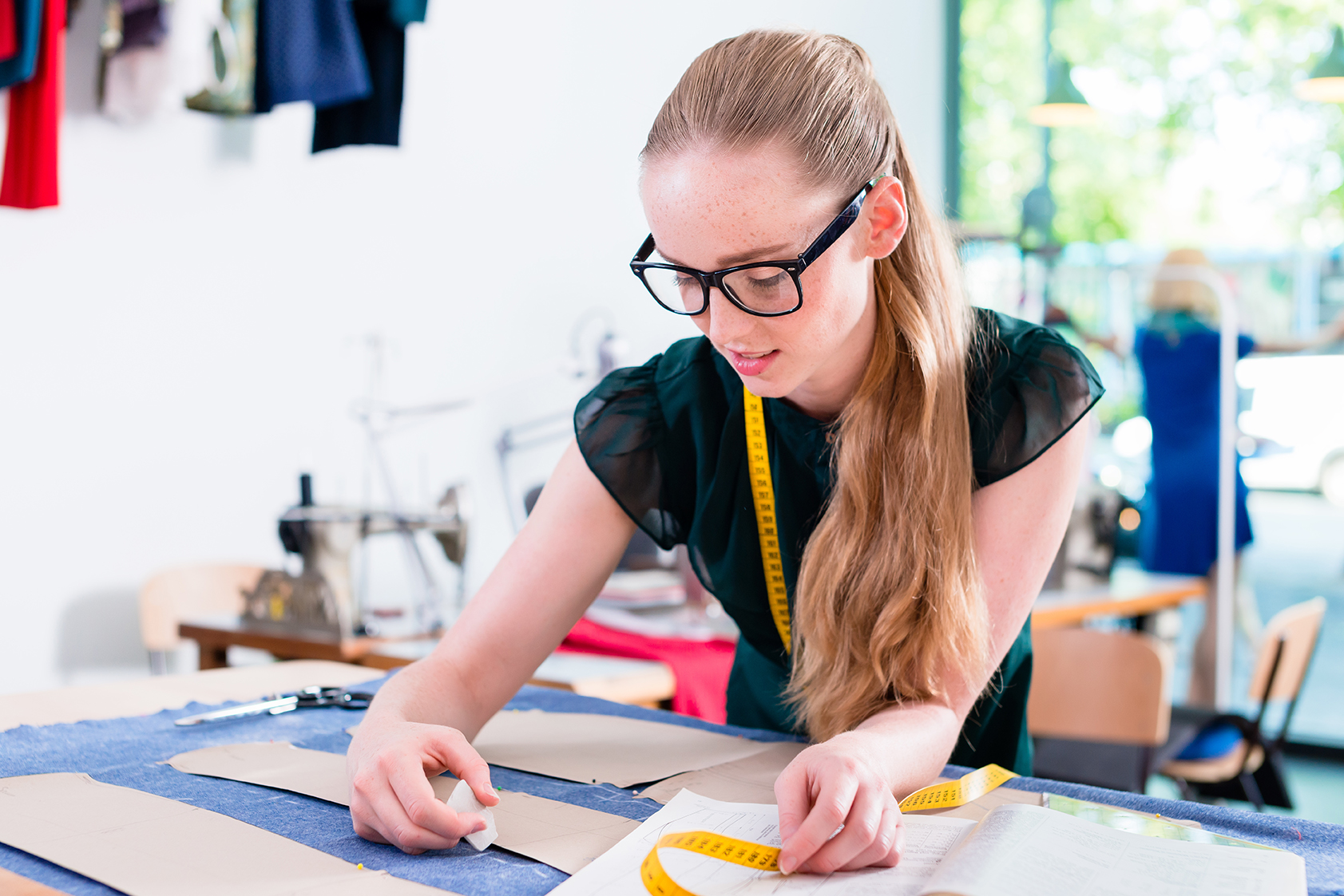 Tailor transfers pattern of fashion design to cloth