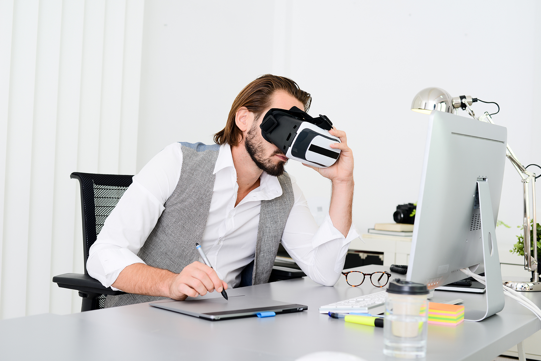 young male software programmer testing new app with 3d virtual reality glasses in office