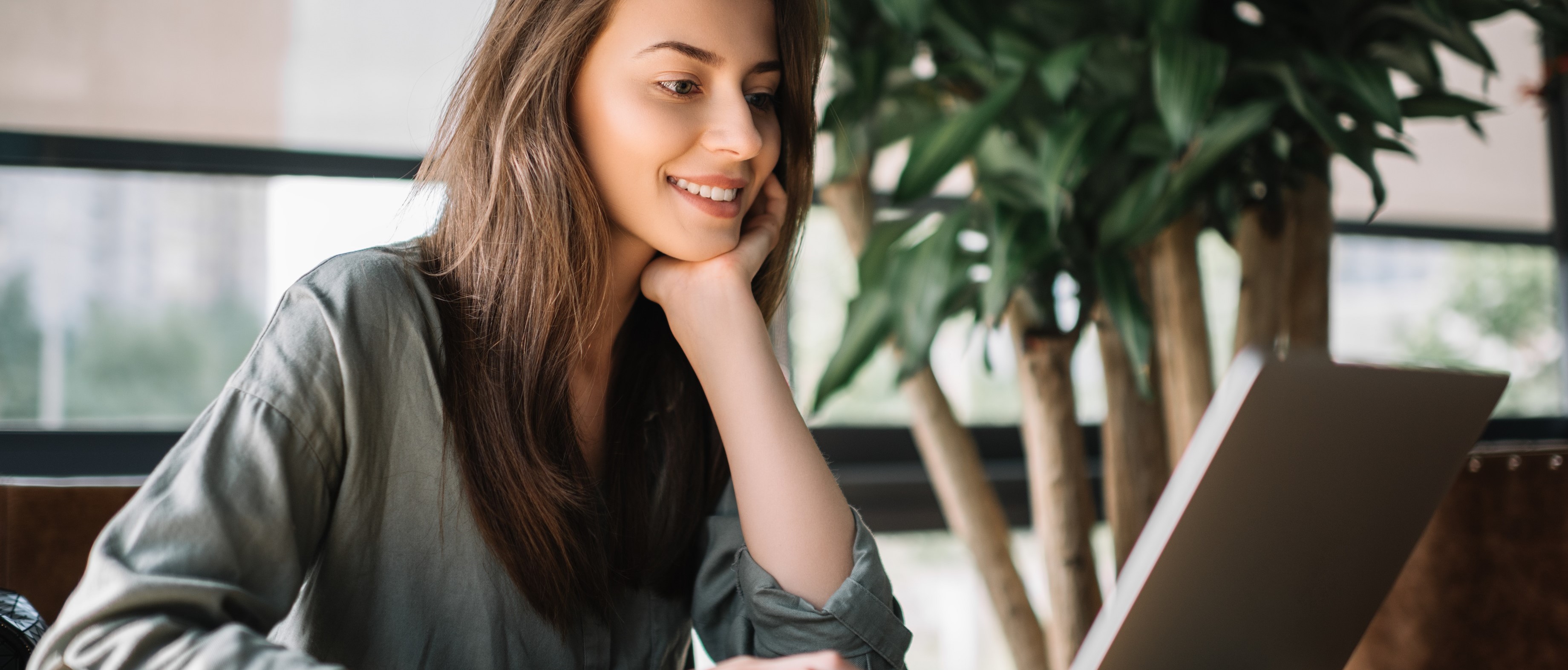 Successful freelancer typing on keyboard using laptop computer in loft office. Portrait of skilled copywriter at workplace.Smiling student learning languages at library, planning project.