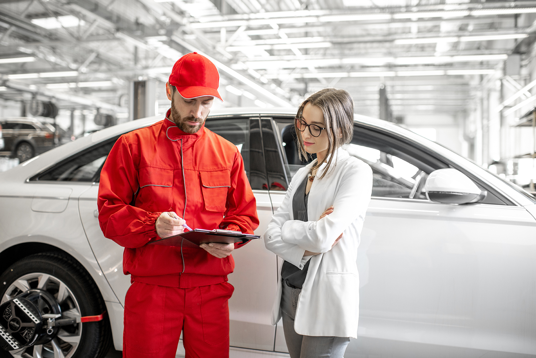 Woman client with auto mechanic at the car service